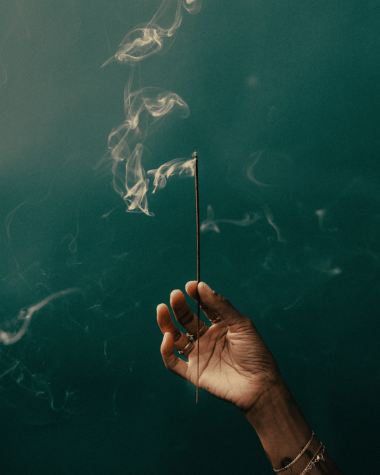 Founder of Acquired Taste Hannah Jackson holding an incense stick smoldering with smoke.