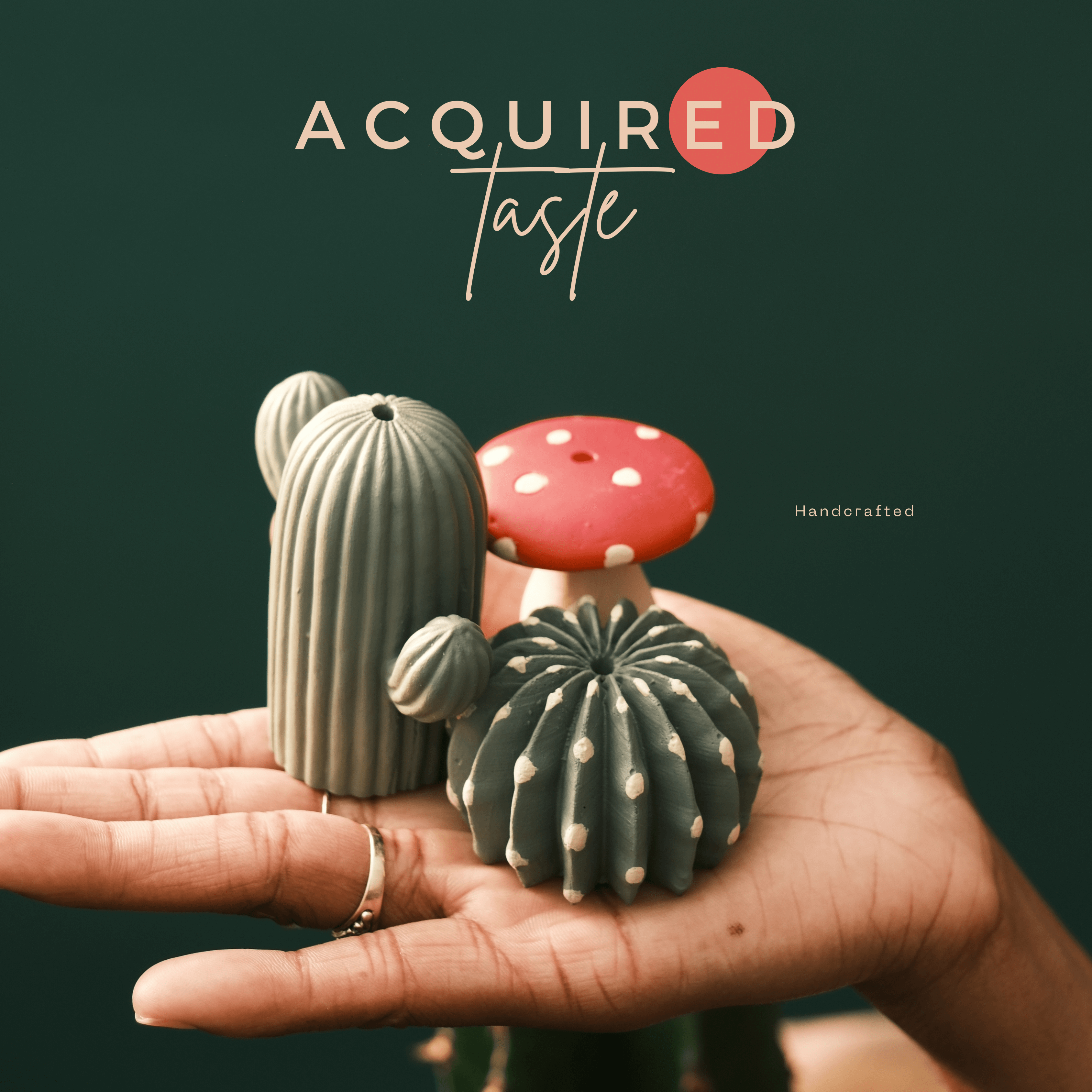 Acquired_Taste_Logo_with_Handcrafted_incense_stick_holders_in_the_shape_of_a_mushroom_and_2_types_of_catcus