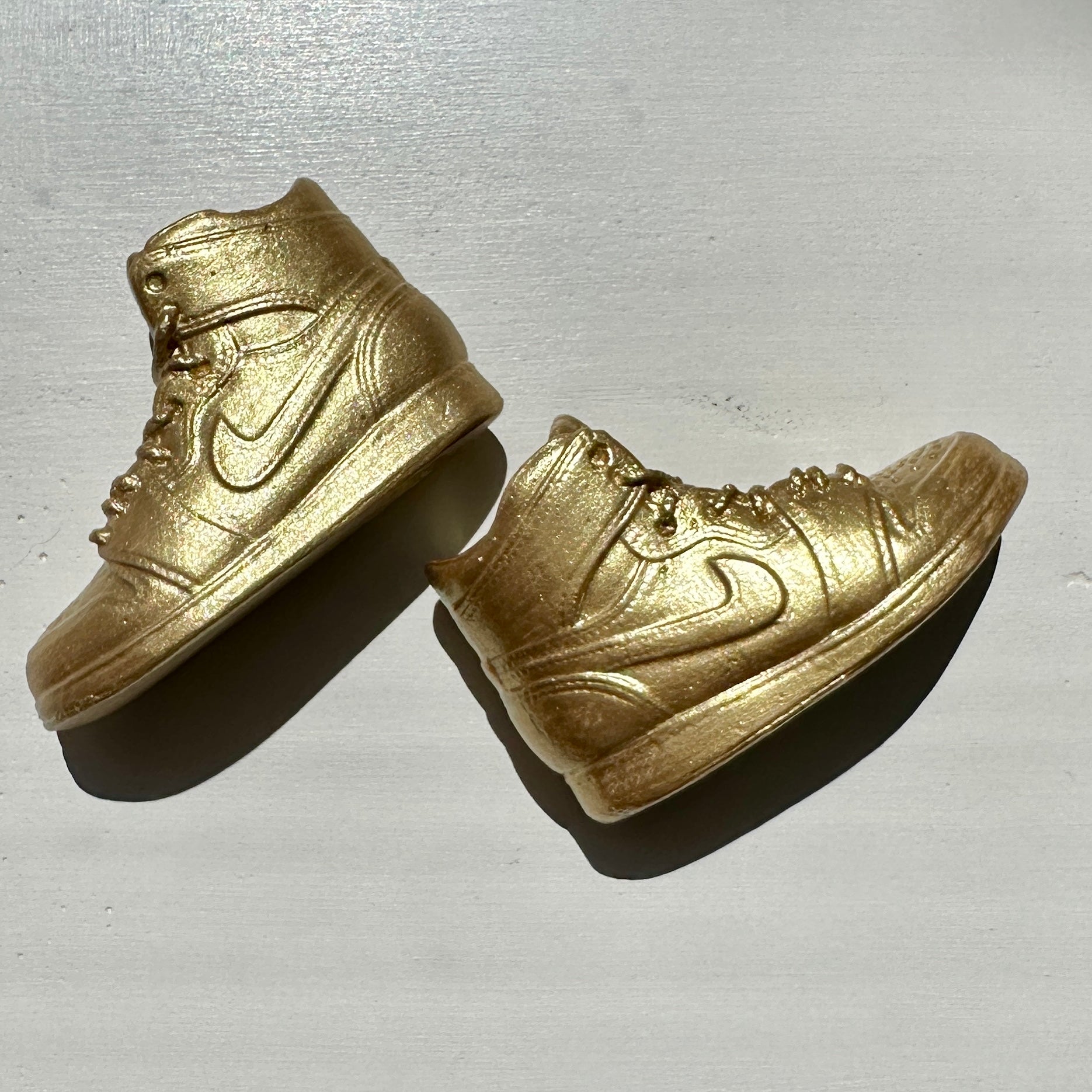 Picture of gold sneakers, side view, incense holders in the replica of Nike miniature shoes