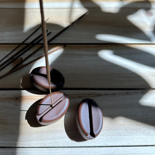 A picture of three incense, coffee, bean holders on wood