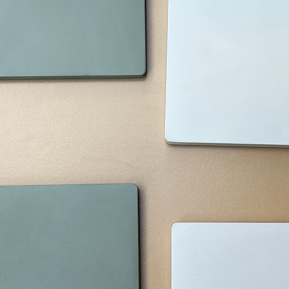 Minimalist ceramic resin incense trays in green and white tones arranged on a beige surface.